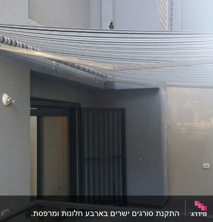 מסגרת מתכת שחורה על דלת זכוכית במרפסת